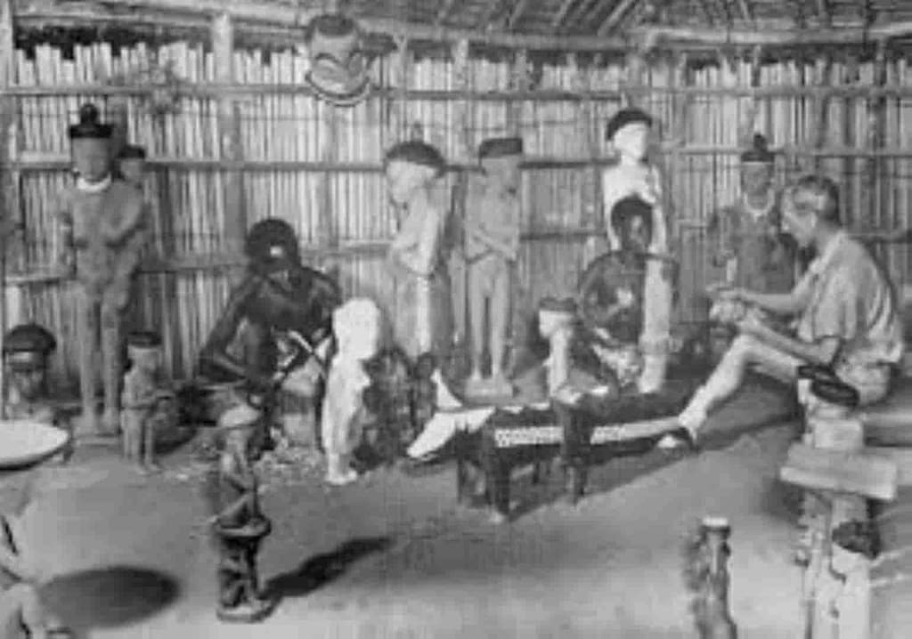 Aunque este ejemplo fotográfico no sea el caso, o sí, es una buena muestra del interés ‘occidental’, reitero lo de que parece que ellos no lo tienen, por los trabajos artesanos, cómo vemos, en que bajo la mirada de un interesado ‘occidental’, se tallan máscaras y figuras en lo que prodríamos llamar un taller pende.
Desconozco todo lo relativo a esta foto, ni datos del autor ni de quienes son los retratados, ni la fecha.